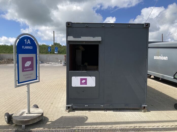 Flamingokomprimering i container på genbrugsplads Flamingokomprimering i container på genbrugsplads