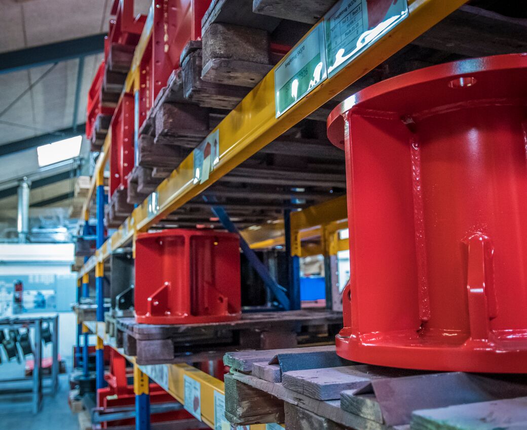 Metaldele opbevaret på paller i et industrielt reollager