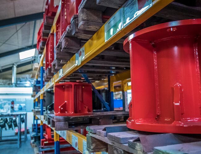 Metaldele opbevaret på paller i et industrielt reollager